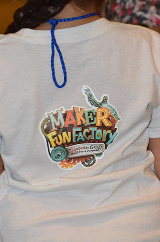 Child in T-Shirt with Maker Fun Factory Logo