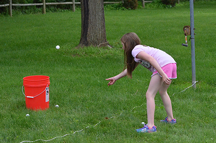 Child Tossing Ball into Bucket